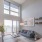 Natural light pours through large living room windows and glass door with access to private balcony