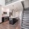 Spacious kitchen with island next to stairs leading to loft in a Boston East apartment home